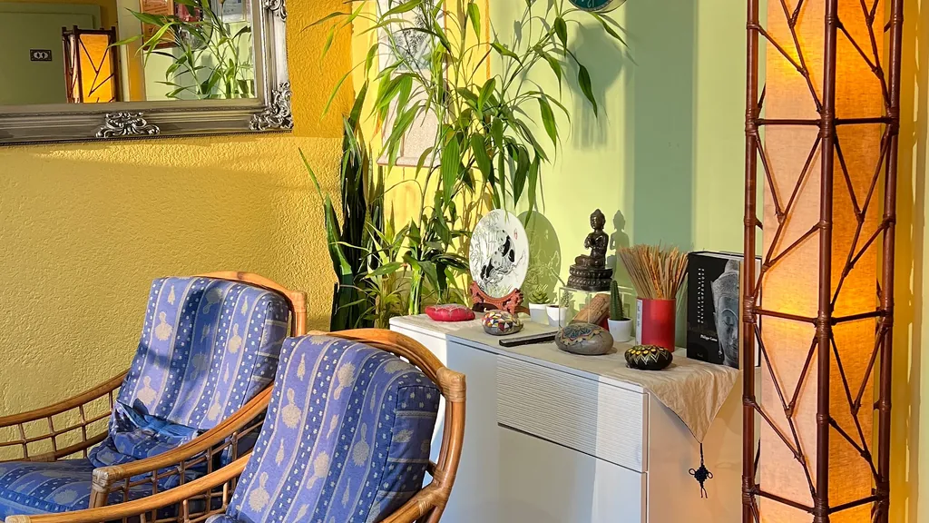 Salle d'attente chaleureuse : fauteuils en rotin, bambous et objets de décoration chinois